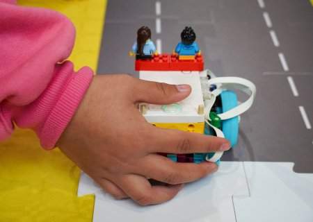 Mano impulsando coche hecho con lego